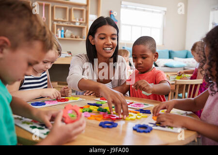 Les élèves et enseignants à l'aide de formes de fleurs en Montessori School Banque D'Images