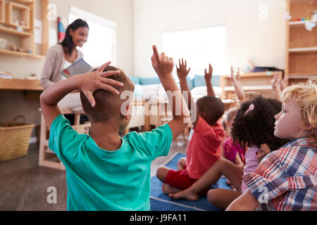 Les élèves à l'École Montessori élever les mains pour répondre à la question Banque D'Images