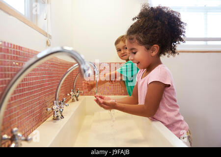 Les élèves à l'École Montessori Lave-mains dans les toilettes Banque D'Images