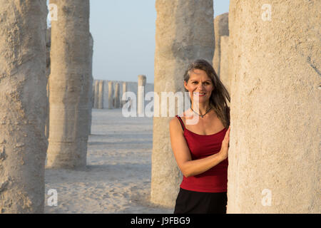 Belle femme ayant l'amusement jouer autour de vieux piliers de béton abandonnées. Banque D'Images