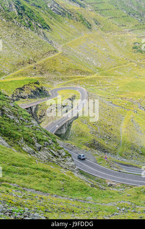 Transfagarasan road serpent de montagnes de Fagaras, Carpates, avec de l'herbe bien verte et des rochers, des nuages de brouillard. Banque D'Images