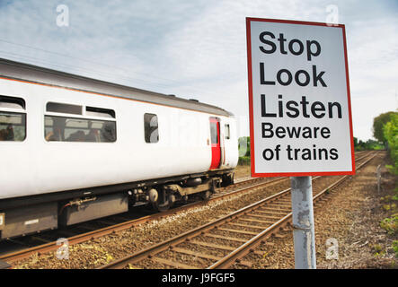Arrêter de regarder Écouter Méfiez-vous des trains signe sur le bord de la voie ferrée en milieu rural que l'norfolk train passe au diesel Banque D'Images