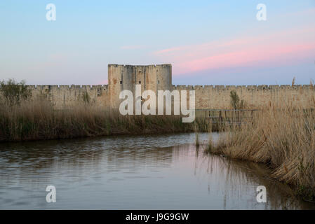 La brunante ou coucher de soleil sur la cité médiévale du sud de l'enceinte de la ville médiévale fortifiée d'Aigues-Mortes Camargue France Banque D'Images