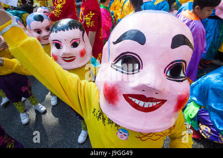 La Chine, Hong Kong, New Years Day annuel Défilé du Festival, les enfants vêtus de masques Bouddha heureux Banque D'Images
