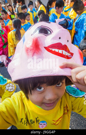 La Chine, Hong Kong, New Years Day annuel Défilé du Festival, avec des enfants heureux masque Bouddha Banque D'Images