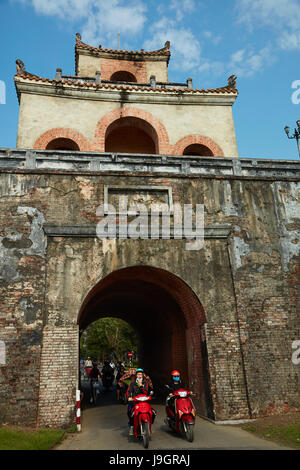 Les motos qui sortent de l'historique porte de la citadelle de Hue (cité impériale), la teinte, la côte centrale du nord du Vietnam, Banque D'Images