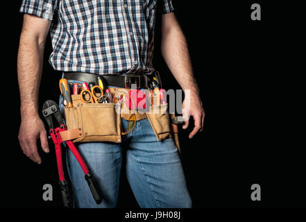 Détail de l'homme en cuir avec toolsbelt et outils sur fond sombre Banque D'Images