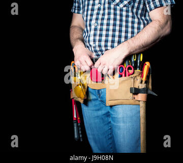 Détail de l'homme en cuir avec toolsbelt et outils sur fond sombre Banque D'Images