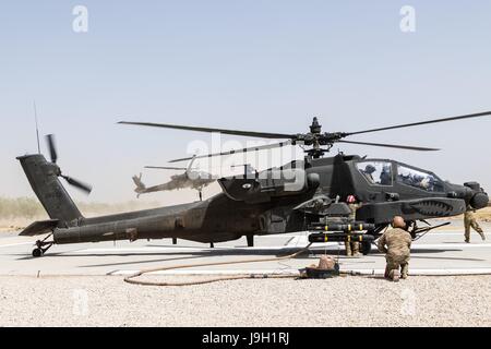 L'ARMÉE AMÉRICAINE AH-64E hélicoptères d'attaque Apache assigné à la Force Griffin, 16e Brigade d'aviation de combat, les rechargements d'armes et de carburant avant de partir en mission à l'appui de l'opération Appui résolu 31 Mai, 2017 à Kunduz, Afghanistan. Kunduz a vu le renforcement de l'activité des talibans comme plus de 8 000 et 6 000 soldats américains de l'OTAN et des pays alliés continuent d'aider le gouvernement. Banque D'Images