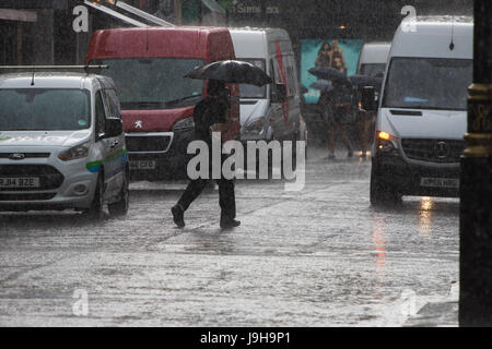 Soho, London, UK. Le 2 juin 2017. Un homme traverse la rue sous l'abri de son parapluie comme l'un des orages prédit par le Met Office passe sur Old Compton Street à Soho, Londres. Crédit : Paul Davey/Alamy Live News Banque D'Images