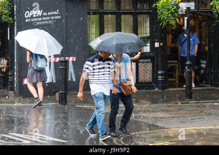 Soho, London, UK. Le 2 juin 2017. Deux hommes partagent un parapluie comme l'un des orages prédit par le Met Office passe sur Old Compton Street à Soho, Londres. Crédit : Paul Davey/Alamy Live News Banque D'Images