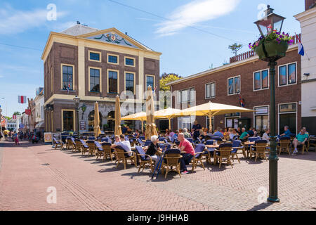 Les gens à une terrasse de restaurant sur place du marché dans la vieille ville de Brielle, Hollande méridionale, Pays-Bas Banque D'Images