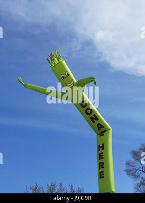 Faites un don ici inflatable cute cartoon character dancing against blue sky Banque D'Images