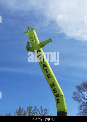 Faites un don ici inflatable cute cartoon character dancing against blue sky Banque D'Images