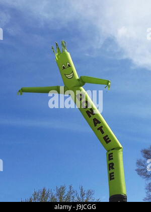 Faites un don ici inflatable cute cartoon character dancing against blue sky Banque D'Images