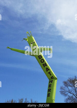 Faites un don ici inflatable cute cartoon character dancing against blue sky Banque D'Images