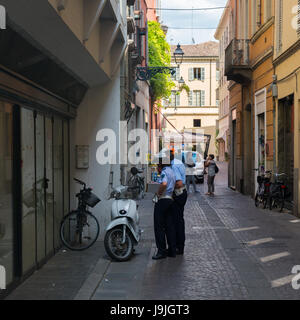 La police de la circulation (Carabinieri) à Parme (Italie) faire un rapport sur une Vespa dans une ruelle Banque D'Images