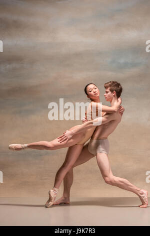 Couple de danseurs de ballet posant sur fond gris Banque D'Images