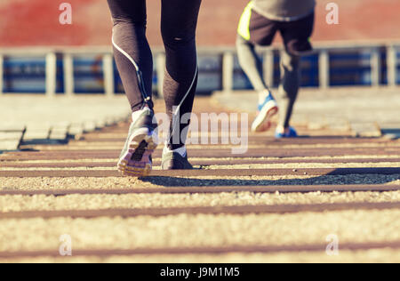 Close up of couple fonctionnant en bas sur stadium Banque D'Images