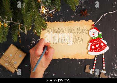 Un crayon dans une main gauche. Il est écrit d'hiver- holidaystravel tips Banque D'Images