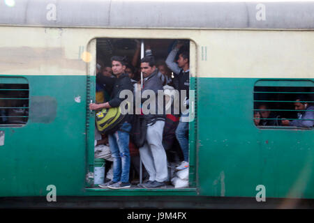 Gens en suspens aux portes ouvertes de commuter train passant par la gare de New Delhi en Inde Banque D'Images