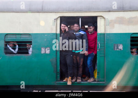 Gens en suspens aux portes ouvertes de commuter train passant par la gare de New Delhi en Inde Banque D'Images