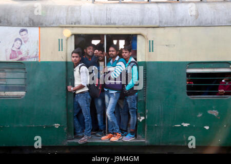 Gens en suspens aux portes ouvertes de commuter train passant par la gare de New Delhi en Inde Banque D'Images