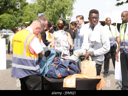 Racegoers passez les contrôles de sécurité sur les femmes au cours de la Journée 2017 Investec Derby d'Epsom Festival à l'hippodrome d'Epsom, Epsom. Banque D'Images