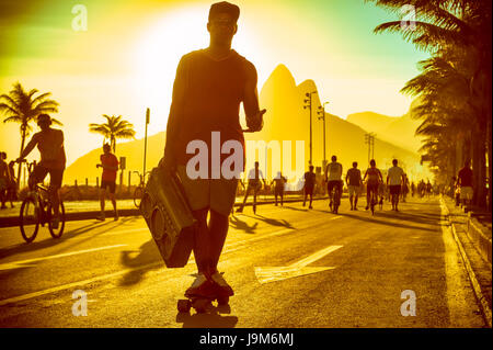 Silhouette de l'homme brésilien avec patinage sur le radiocassette en bord d'Ipanema à Rio de Janeiro, Brésil Banque D'Images