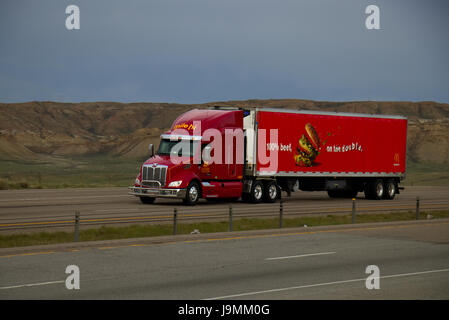 Un rouge "Ile-Hi' Peterbilt Semi-Truck tire un McDonald's rouge remorque le long d'une chaîne alimentaire nous rural Interstate. Banque D'Images