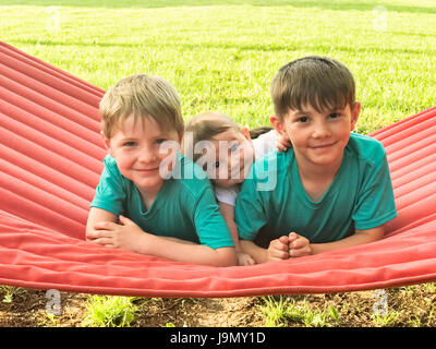 Trois garçons sur le hamac rouge Banque D'Images