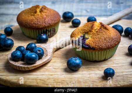 Muffins aux bleuets avec des bleuets sur des cuillères en bois et bois Banque D'Images