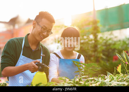 Photo de deux jeunes chinois travaillant dans la boutique de fleuriste Banque D'Images