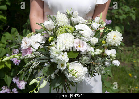 La mariée est la tenue d'un bouquet de mariage dans les tons blancs, roses, lisianthus de dahlias et d'eucalyptus Banque D'Images