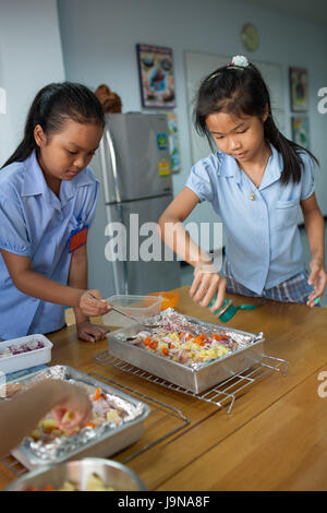 Bangkok, Thaïlande - 23 novembre 2012 : dans le cadre d'un collège à Bangkok en Thaïlande. Les jeunes étudiants suivent un cours d'introduction dans la cuisine avec leur enseignant Banque D'Images