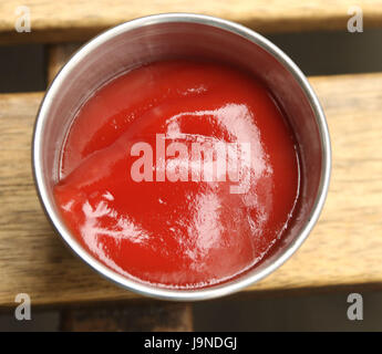Le ketchup en argent ronde conteneur sur une table de pique-nique Banque D'Images