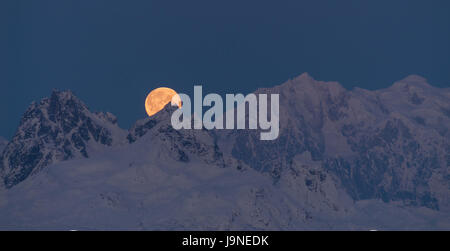 La lune émerge de derrière les montagnes en Denali Banque D'Images