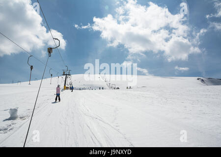 Petite fille aux débutant skis monte avec téléskis Banque D'Images