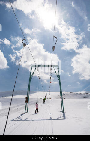 Petite fille aux débutant skis monte avec téléskis Banque D'Images