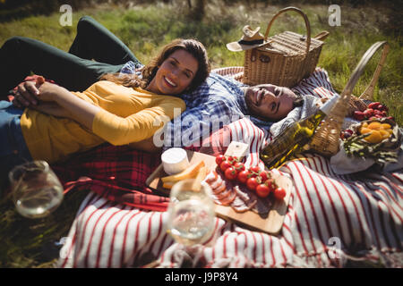 Portrait of happy young couple lying together sur couverture à la ferme d'olive Banque D'Images