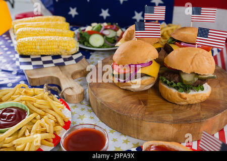 Close-up de burgers et d'épis de maïs sur table en bois avec 4 juillet THÈME Banque D'Images