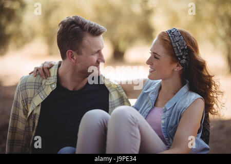 Close up of smiling young couple sitting on champ à la ferme d'olive Banque D'Images