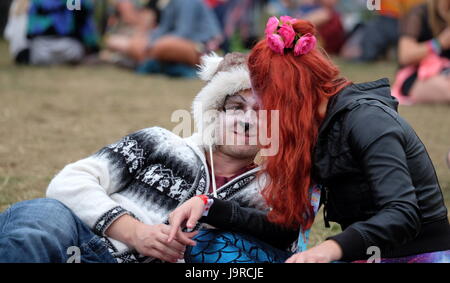 Deux jeunes festivaliers avec visages peints couché chatting at Festival Bestival sur l'île de Wight, 9 septembre 2016 Banque D'Images