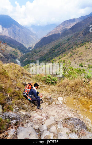 Trekker en faisant une pause sur le circuit de l'Annapurna près de Lili Bhir. Banque D'Images
