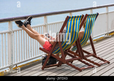 Bournemouth, Dorset, UK. 3 juin, 2017. Météo France : refroidisseur et plus nuageux avec éclaircies à Bournemouth - les visiteurs à la tête de la mer plages de Bournemouth. Couple assis dans des chaises longues sur la jetée de Bournemouth. Credit : Carolyn Jenkins/Alamy Live News Banque D'Images