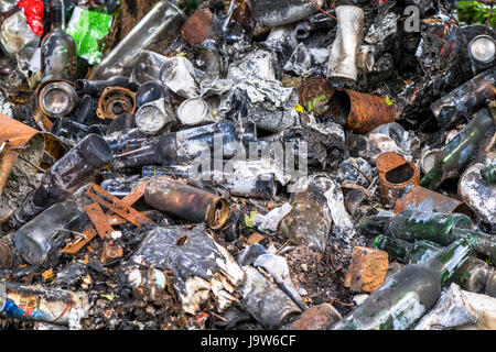 Jeter des bouteilles en verre, des canettes de bière et brûlés dans un embout de mouche. Banque D'Images