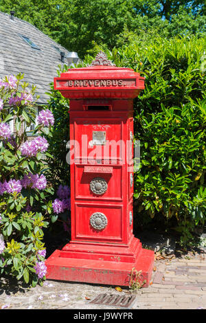 Ancienne boîte aux lettres néerlandaises rouge dans une rue du village d'Orvelte Banque D'Images