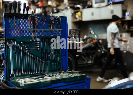 Image en arrière-plan de la boîte à outils ouverte avec divers tournevis et clés sur le stand de l'atelier de réparation automobile Banque D'Images