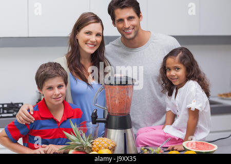 Family posing avec un mixeur dans la cuisine Banque D'Images