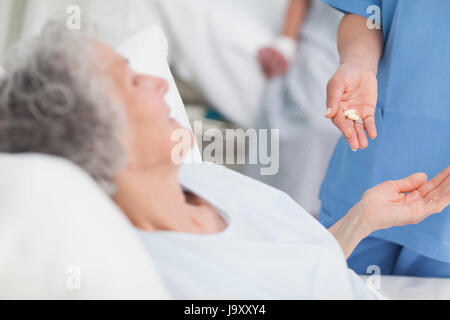 L'administration de médicaments aux infirmières un patient âgé in hospital ward Banque D'Images